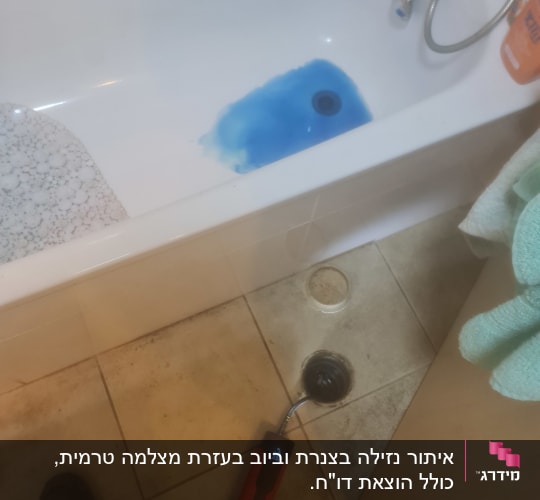אמבטיה עם מים כחולים, מכשיר בדיקה על הרצפה